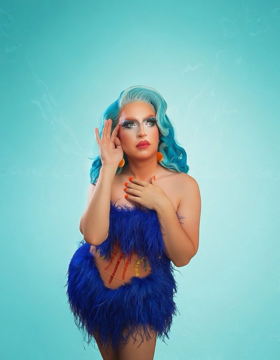 Irene Bru portrait in a blue feather look on a teal backdrop